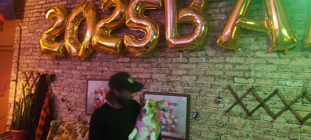 Levi Andersen, owner of 5BAR, looks at his dog, Lady, inside the bar on Thursday.